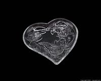 Top view of clear heart-shaped dish showing embossed hummingbird and flowers