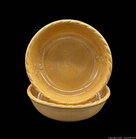 Two matching gold ceramic bowls stacked to show interior design