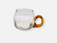 Full view of clear optic glass mug with amber handle