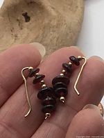 Front view of both earrings showing garnet beads and gold hooks