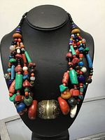 Full view of necklace on display form showing multi-strand design and large central bead