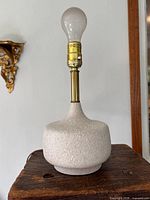 Front view of pottery lamp with bulb and brass socket