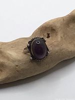 Front view of sterling silver amethyst ring on driftwood prop