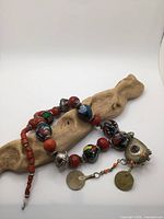 Overall view of necklace showing coral, glass beads, metal spacers and drops