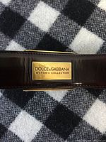 Gold-tone Dolce & Gabbana logo plaque on patent leather belt
