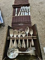 Open roll case showing knives, forks, spoons and ladle