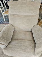 Front view of beige recliner showing upholstery and padded arms