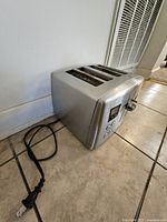 Front and top view of brushed stainless 4-slot Cuisinart toaster showing cord