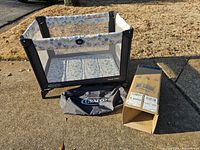 Assembled Graco playard, carry bag, and box on driveway