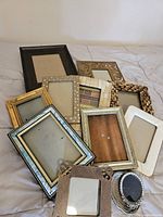 All 12 assorted frames arranged on surface showing variety of materials and finishes