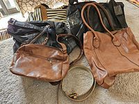 Group of bags and belt laid out showing materials and colors