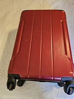 Suitcase exterior showing red hardshell, ridged design and spinner wheels