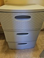 Front view of first light gray 3-drawer plastic organizer showing woven texture and handles