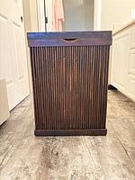 Front view of vertical slat bamboo hamper, closed lid