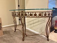 Full view of console table showing glass top, star motif apron and legs