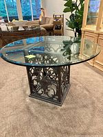 Full room view of round glass table with iron base
