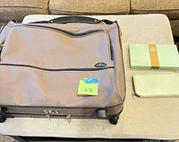 Samsonite garment bag and mint green wallet on table