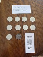 All 10 coins laid out on table with note, full lot overview