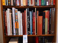 Upper shelf showing multiple hardcover coffee table books with readable titles