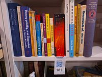 Shelf with fourteen Dutch-language books showing all titles and spine details