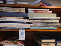 Overall stack of design, entertaining and etiquette books on shelf with tag visible