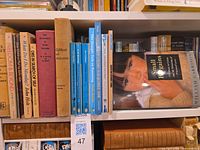 All spines of books showing titles and authors on shelf