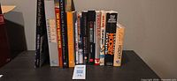 Front view of 12 hockey-related books standing upright showing all spines