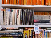 Spines of Raven paperbacks and hardcovers on shelf