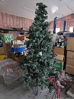 Full view of assembled green artificial Christmas tree on metal stand