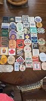 Full overhead view showing approximately 60 assorted Canadian beer coasters laid out on a table