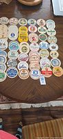 Top-down view of entire assortment of German beer coasters laid out on a table