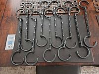 Ten black cascading hanger organizers laid out showing hooks and five-slot bars