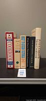 Five cookbooks standing upright on shelf