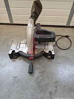 Front view of Craftsman miter saw showing blade guard, base, miter scale, dust bag and broken carrying handle