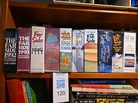 Row of ten boxed Far Side desk calendars 1992-2001 on shelf