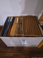 Top view of box showing assortment of colored hanging folders on left and many brown accordion pockets on right