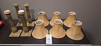 four spiral candlesticks and six lamp shades on shelf