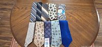 Ten assorted ties laid out on table
