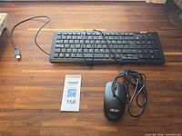 Keyboard and mouse with cords displayed on tabletop