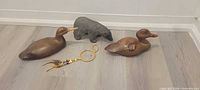 Lot overview showing two wooden duck decoys, resin polar bear figurine and dreamcatcher