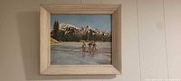 Full view of framed mountain scene painting on wall