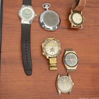 Group shot of all six watches on wooden surface