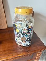 Full view of jar filled with assorted buttons