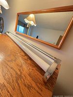 Full length view of chrome fluorescent vanity fixture on wood surface