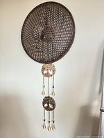Full view of metal wall hanging wind chime on wall