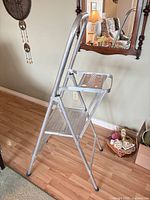 Side view of folded aluminum 3-step ladder