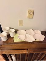 Platter and three mugs displayed on sideboard