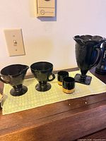 Group view of all five black glass pieces on table