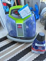 Carpet cleaner with hose and cleaning solution bottle