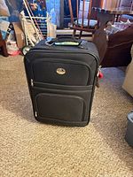 Front view of black Jetstream carry-on suitcase showing exterior zip pockets and logo badge